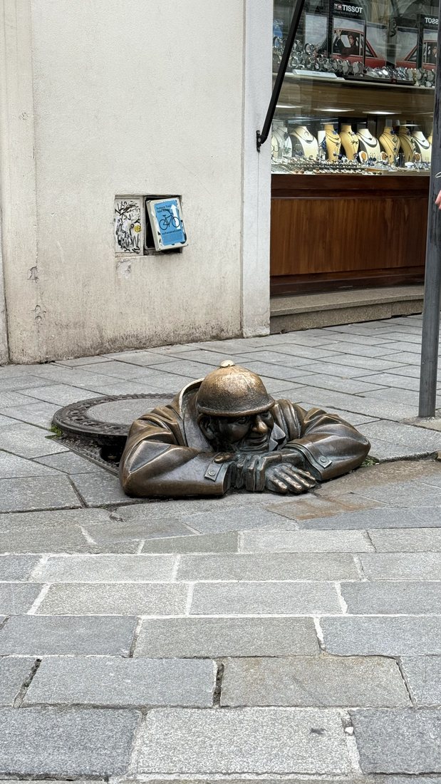 Čumil, the bronze man peeking from a manhole